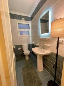 a bathroom with a sink and a toilet and a mirror at Madinaty in Madinaty +21 photos