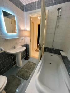 a bathroom with a white tub and a sink at Madinaty in Madinaty