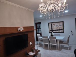 uma sala de estar com uma mesa de jantar e um lustre em Rhodes I a Beira-mar da Jatiuca/Ponta Verde em Maceió
