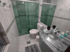 uma casa de banho com um lavatório, um chuveiro e um WC. em Rhodes I a Beira-mar da Jatiuca/Ponta Verde em Maceió