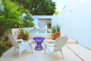 un patio con 2 sedie, un tavolo e una piscina di Casa Violeta a Mérida