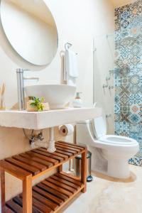 bagno con lavandino, servizi igienici e specchio di Casa Violeta a Mérida