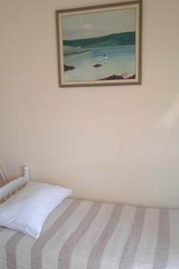 a painting hanging on a wall above a bed at Apartment Ostricka luka 11451b in Zaglavice