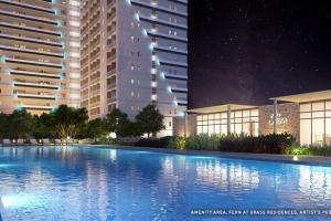 una gran piscina frente a los edificios por la noche en Grass Residence Tower 3 20th, en Manila
