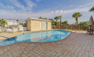 a swimming pool in a yard with a fence at Sand Castles West II G6- NEW in Panama City Beach