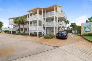 a building with a car parked in a parking lot at Sand Castles West II G6- NEW in Panama City Beach