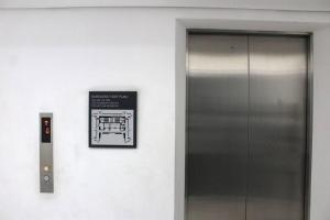 a elevator with a sign next to a door at Abreeza 1BR condo w/ balcony,wifi & Netflix in Davao City