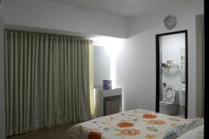 a bedroom with a bed and a bathroom with a mirror at Abreeza 1BR condo w/ balcony,wifi & Netflix in Davao City
