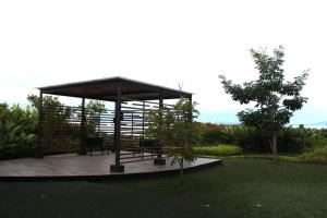 a gazebo with two benches in a garden at Abreeza 1BR condo w/ balcony,wifi & Netflix in Davao City