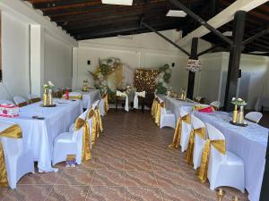 una fila de mesas y sillas en una habitación en Hospedaje Campestre El Deseo, en El Caimo