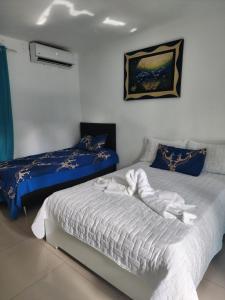 een slaapkamer met 2 bedden met blauwe en witte lakens bij Blue Pool Sol Caribe in Punta Cana