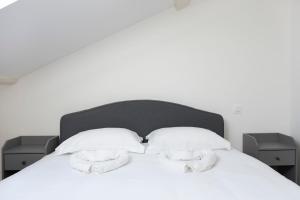 ein weißes Bett mit zwei weißen Handtüchern darauf in der Unterkunft Le Havre Tervillois - A FERMER in Terville