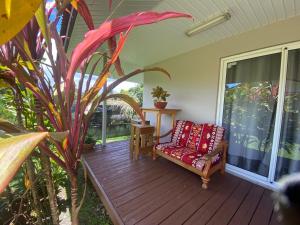 a porch with a chair on a wooden deck at TAHITI - Bungalow Toah Piti in Taravao