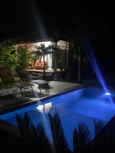 a pool at night with two chairs and a table at TAHITI - Bungalow Toah Piti in Taravao +5 photos