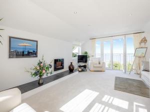 a living room with white furniture and views of the ocean at Heath Lodge in Brixham
