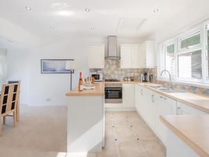 a kitchen with white cabinets and a counter top at Heath Lodge in Brixham