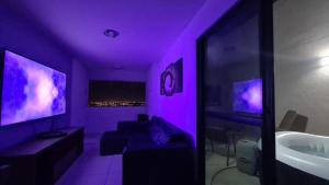 um quarto roxo com um sofá e um lavatório em Cobertura Panorâmica 20º andar - com Hidro-Spa aquecido em Maceió