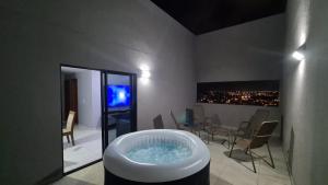 uma casa de banho com uma banheira e uma televisão. em Cobertura Panorâmica 20º andar - com Hidro-Spa aquecido em Maceió