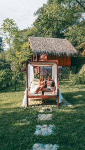 two people laying on a bed in a swing at Bio Rio Hotel in San Jerónimo