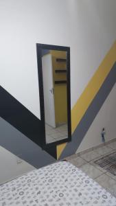 um espelho com uma porta num quarto em Quarto individual masculino em São José do Rio Preto