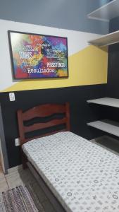 a bedroom with a bed and a tv on the wall at Quarto individual masculino in Sao Jose do Rio Preto