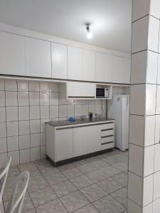 uma cozinha com armários brancos e um frigorífico branco em Quarto individual masculino em São José do Rio Preto