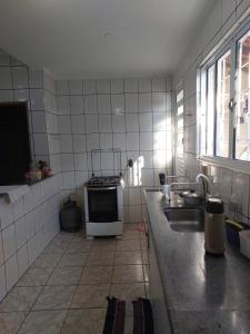 a kitchen with a sink and a stove in it at Quarto individual masculino in Sao Jose do Rio Preto