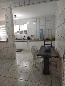 uma cozinha com mesa e cadeiras num quarto em Quarto individual masculino em São José do Rio Preto