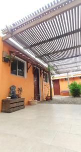 a patio with a pergola in front of a building at Aparts Complejo Arinos in Aguas Dulces