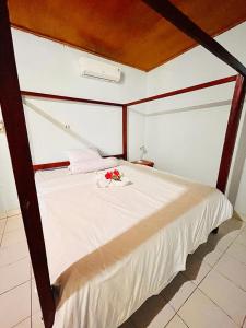 Un dormitorio con una gran cama blanca con flores. en Kurnia Family Home Stay en Huu