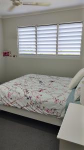 a bedroom with a bed with flowers on it at Hidden Gem Holiday Let in South Mission Beach