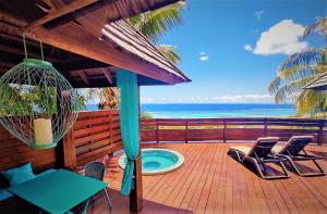 una terrazza con sedie, una piscina e l'oceano di MOOREA - Villa Ana Mua a Papetoai