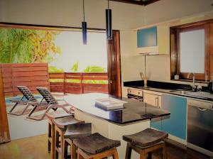 una cucina con tavolo, alcune sedie e lavandino di MOOREA - Villa Ana Mua a Papetoai