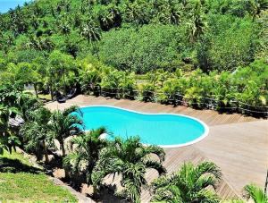 una vista dall'alto di una piscina con palme di MOOREA - Villa Ana Mua a Papetoai