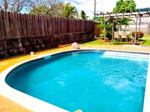 una grande piscina blu in un cortile sul retro di TAHITI - Lihei Pool House a Faaa