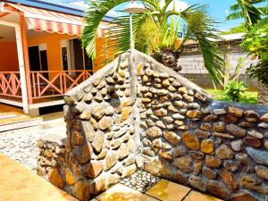 uma parede de pedra em frente a uma casa em TAHITI - Lihei Pool House em Faaa