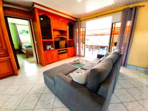 sala de estar con sofá y cocina en TAHITI - Lihei Pool House, en Faaa
