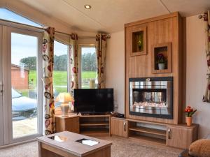 a living room with a tv and a fireplace at Ashness - Uk44966 in Plumbland