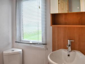 a bathroom with a toilet and a sink and a window at Ashness - Uk44966 in Plumbland