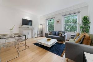 a living room with a couch and a fireplace at Knightsbridge Two Bed Apartment in London