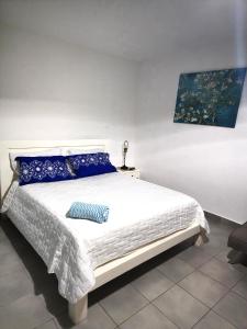 een slaapkamer met een groot wit bed met blauwe kussens bij Blue Pool Sol Caribe in Punta Cana