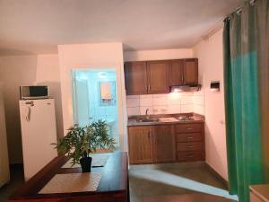 een keuken met houten kasten, een tafel en een koelkast bij Blue Pool Sol Caribe in Punta Cana +15 foto's