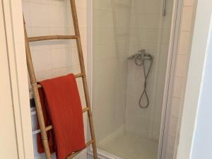 a shower with a red towel on a ladder at Charmant T2 climatisé à Biscarrosse Plage, à 2 min de la mer, avec balcon et parking inclus - FR-1-319-392 in Biscarrosse-Plage