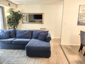 uma sala de estar com um sofá azul e um espelho em Sweet Suite in Central Raleigh em Raleigh