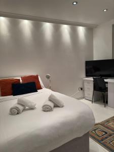 a bedroom with a large bed and a flat screen tv at St Paul's Farringdon Longstay Cozystay in London