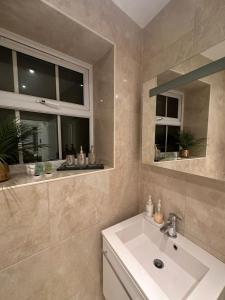 baño con lavabo y ventana en St Paul's Farringdon Longstay Cozystay, en Londres