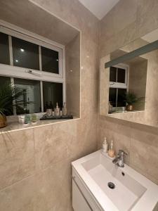 a bathroom with a sink and a window at St Paul's Farringdon Longstay Cozystay in London