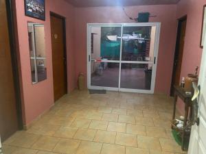 pasillo con puerta de cristal en una habitación en Casa de Campo La Maribel, en La Lucila del Mar