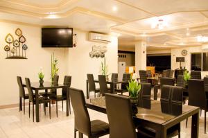 a restaurant with tables and chairs and a flat screen tv at Allson's Inn in Cebu City