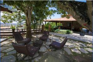 a group of chairs sitting on a patio under a tree at Loc10flats 3 Quartos - Residencial Monte Castelo in Bezerros